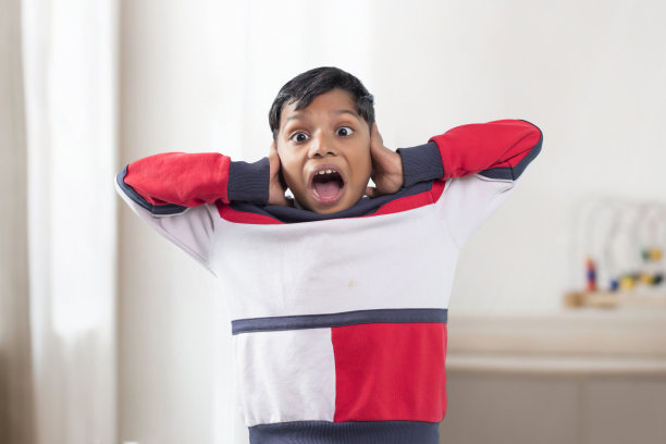 一个穿着t恤的小男孩，双手放在头上尖叫图片下载