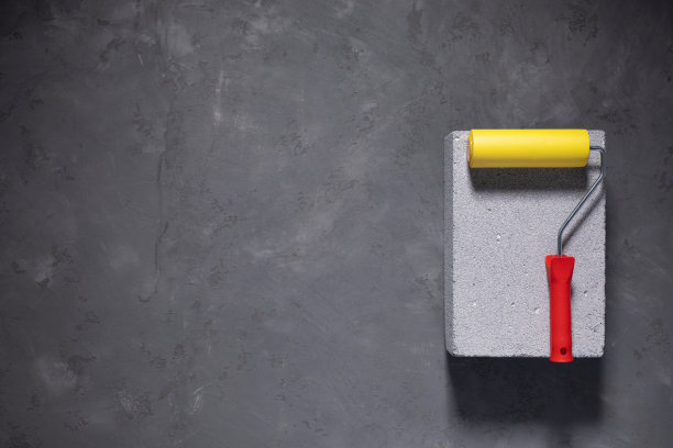 水泥地面上的油漆辊。工具构造概念有具体的背景图片下载