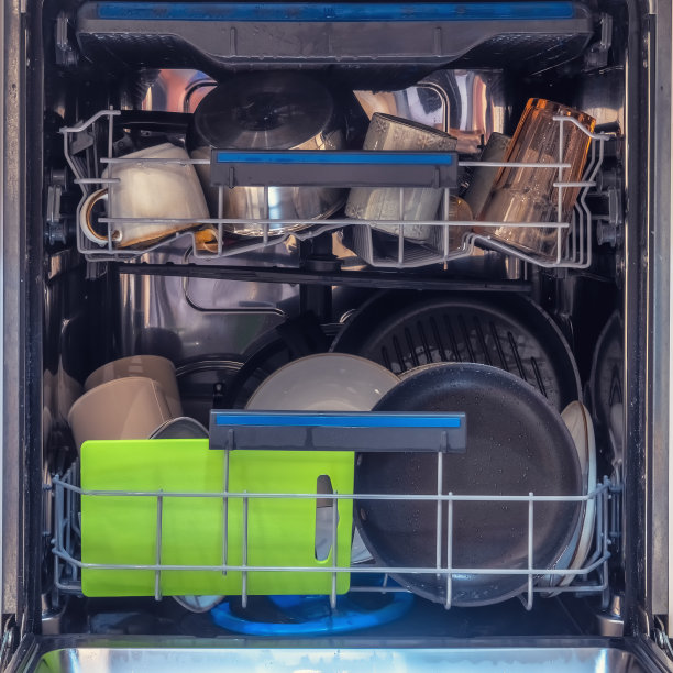 洗碗机里装满了洗过的干净盘子。开着门的洗碗机，里面有洗过的盘子和杯子图片下载