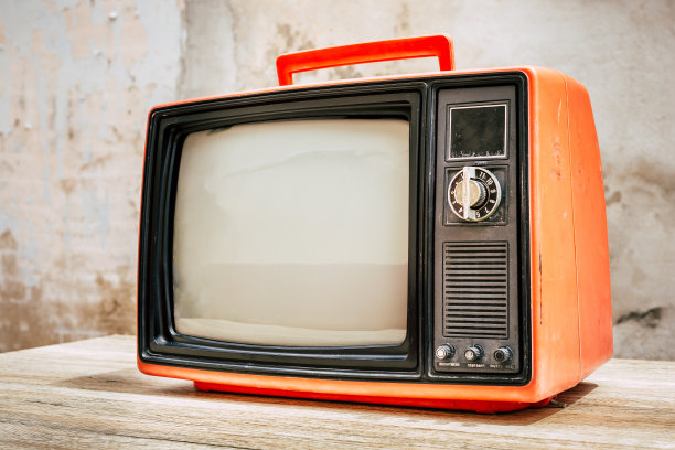 复古的红色老电视在木桌与旧的混凝土墙背景。老式电视滤镜照片图片下载