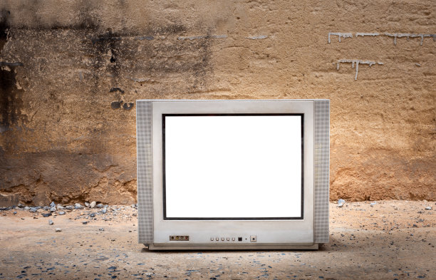 CRT平面电视与切割屏幕在地板和旧的墙壁背景图片下载