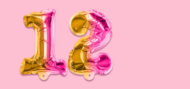 彩虹箔气球号码，数字12在粉红色的背景。有题词的生日贺卡图片下载