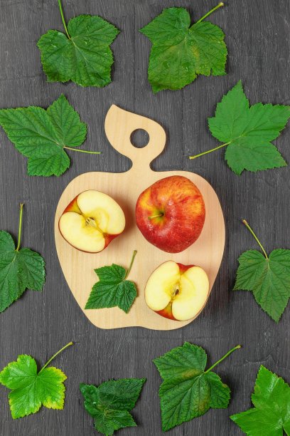 两个新鲜的苹果和黑加仑子的叶子一起躺着图片下载