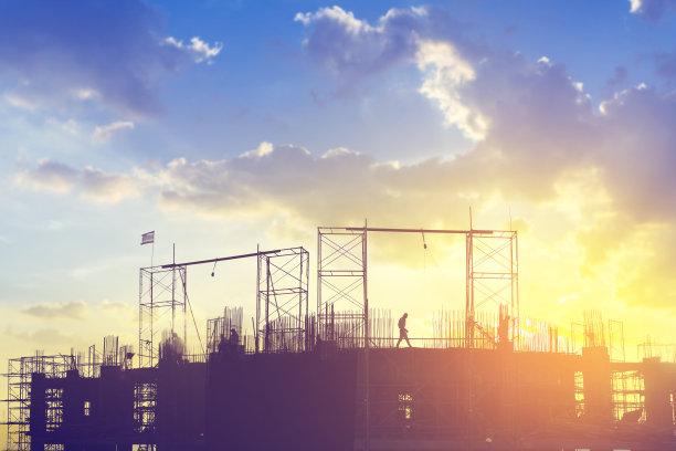 夕阳下建筑工地的剪影。图片下载