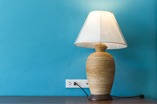 台灯放在木桌上，蓝色的墙壁背景上有空间图片下载