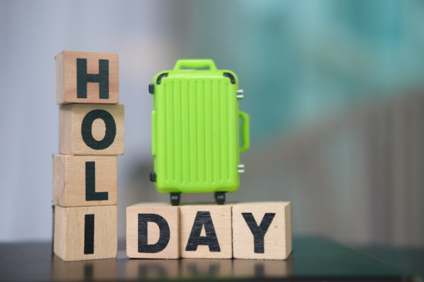 绿色行李箱上的木块文字假期。图片下载