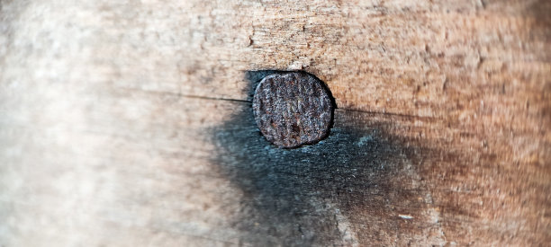 钉子卡在墙上的微距照片图片下载