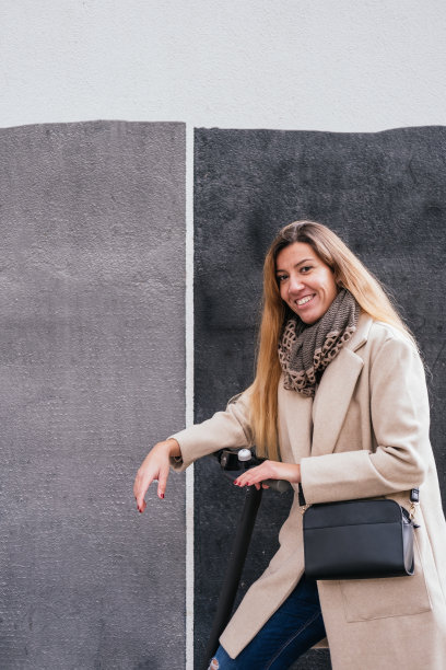 千禧一代女性使用电动滑板车进行城市交通图片下载