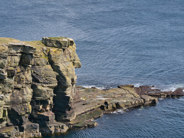 位于英国设得兰群岛桑威克附近海岸悬崖顶部的一块大块岩石。可能由冰川作用沉积。这些悬崖是布雷塞石板地层的一部分。图片下载