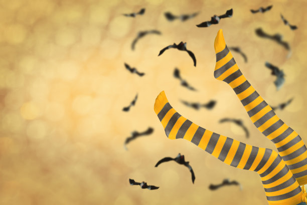 在万圣节节日背景下，穿着条纹丝袜的女人的腿图片下载