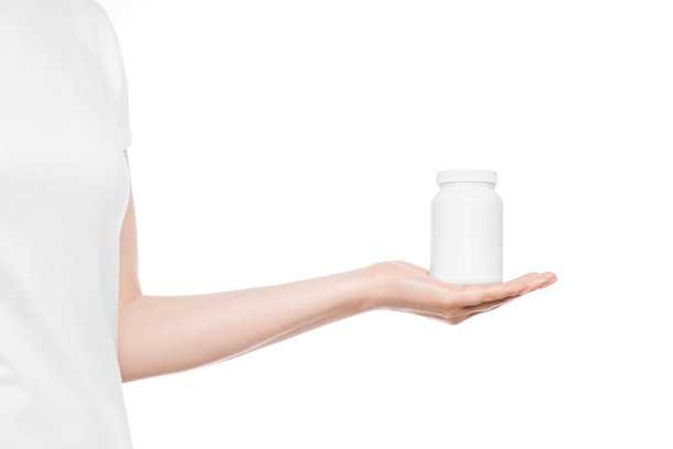 横幅上是一个穿着白色t恤的女人，手里拿着白色的塑料瓶。复制空间，位置的标志或品牌。图片下载