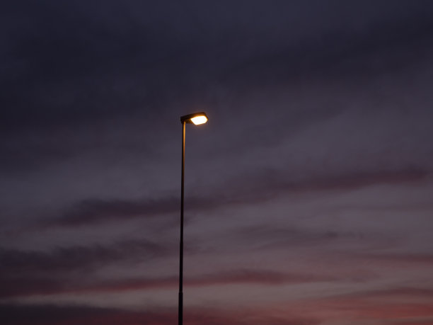 路灯在夕阳中点亮，路灯在夜晚点亮，灯光在黑暗中概念图片下载
