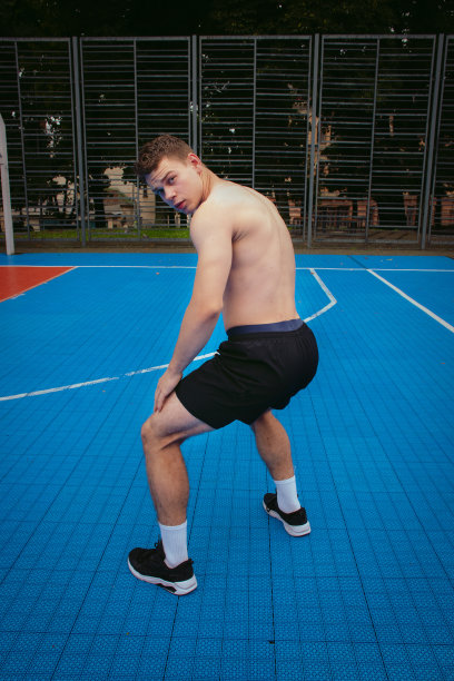 英俊的赤膊年轻人在运动场上跳电臀舞。健身与运动动机图片下载