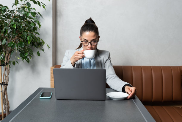 熟练的女程序员戴着保护眼睛的眼镜通过笔记本电脑自由工作，聪明的学生在食堂看上网本教程满足e学习课程图片下载