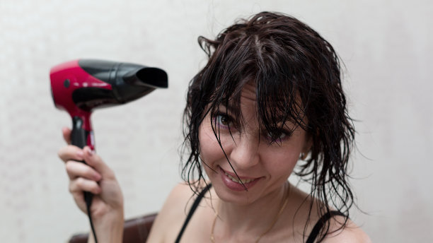 女子在早晨淋浴后吹干头发图片下载