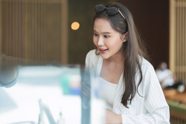 微笑放松休闲的亚洲女性成年女性幸福快乐的选择精致的巧克力蛋糕和糖果在咖啡馆橱柜展示咖啡馆背景，休息一下工作后的周末时刻图片下载