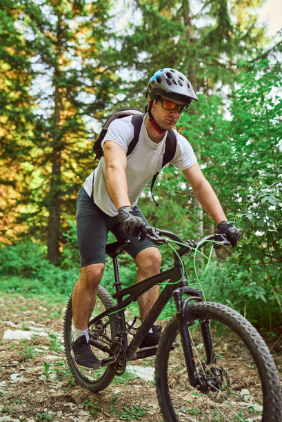 一个骑自行车的人在极端和危险的森林道路上骑自行车。有选择性的重点图片下载
