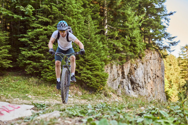 一个骑自行车的人在极端和危险的森林道路上骑自行车。有选择性的重点图片下载
