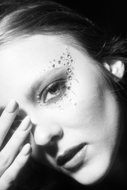 美丽的女人肖像与粘合珠宝在她的脸上图片下载