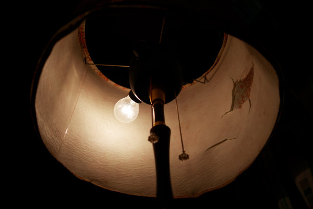 古老的落地灯，在黑暗中有一个燃烧的灯泡。图片下载