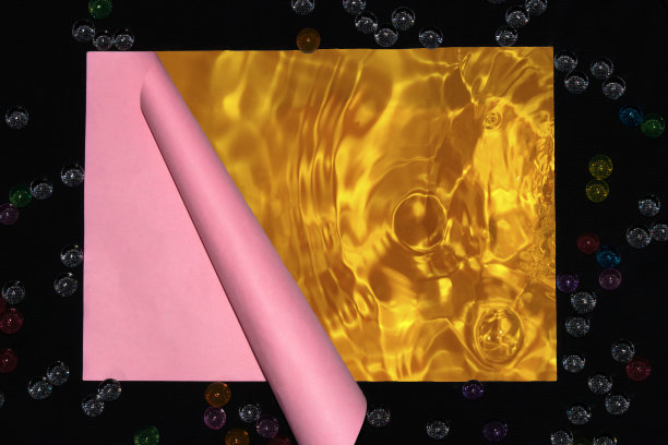 粉红色的纸展开，下面是黄色的水背景，空间中的水纸，创意的复制空间，创意的艺术现代设计图片下载