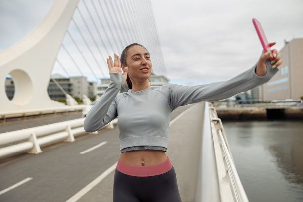 穿着运动服的美女在城市跑步后休息和视频通话图片下载