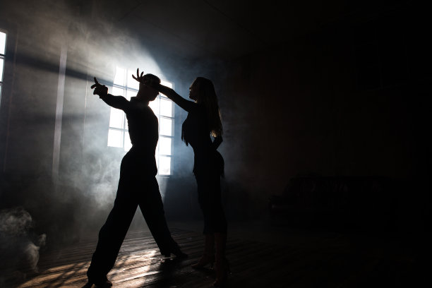 一对专业交谊舞舞者正在阁楼工作室跳舞。美丽的艺术表现与沉重的烟雾。运动生活的概念。激情与情感的舞蹈。图片下载