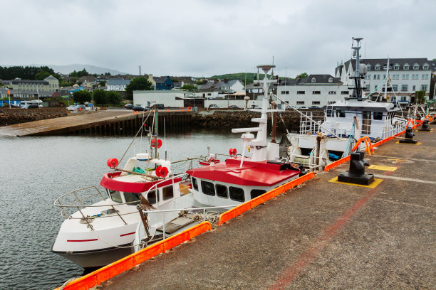 一艘纵帆船停泊在渔村的码头上。图片下载