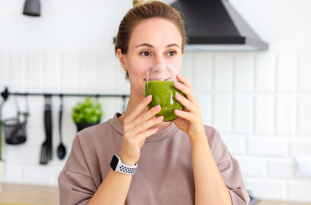 健康的生活方式，减肥的理念。女人喝绿色奶昔的肖像特写。年轻女性喝减肥鸡尾酒。健康食品,早餐图片下载