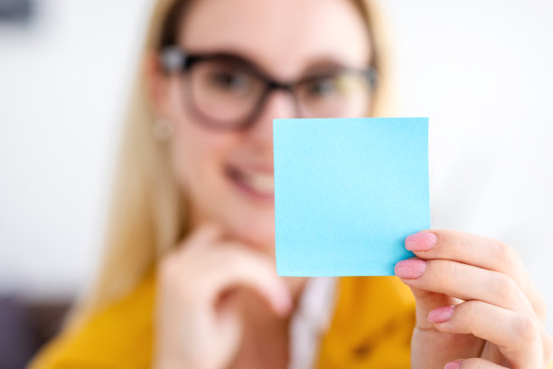 成功的年轻女商人手里拿着一张小纸片特写，拷贝空间图片下载
