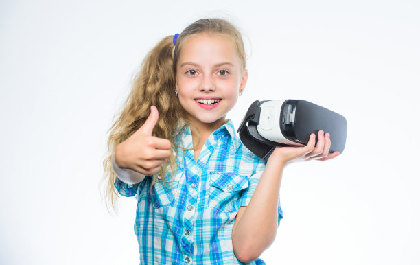 快乐的孩子使用现代科技。VR头盔里的小孩。小女孩戴着虚拟现实眼镜。数字未来与创新。小孩子戴上无线VR眼镜。现代技术图片下载