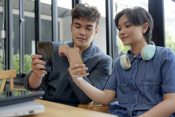 年轻人一起使用不同的智能手机。图片下载