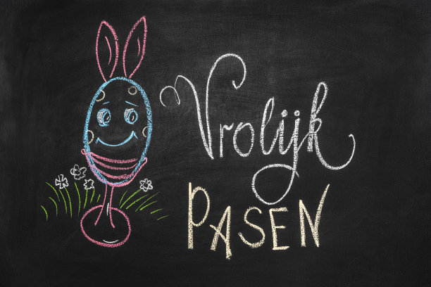 黑板上画着美丽的复活节彩蛋，彩蛋上有小兔子，上面写着“复活节快乐”图片下载