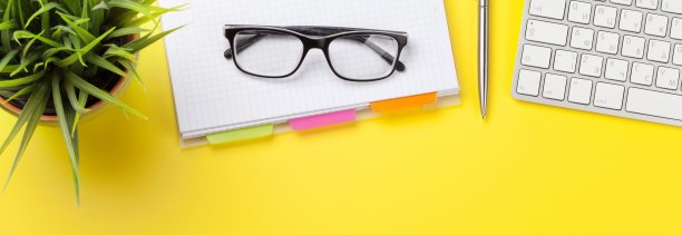 办公室黄色背景，配有办公用品和电脑图片下载