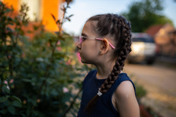 带着辫子和眼镜的可爱女孩的侧面视图图片下载