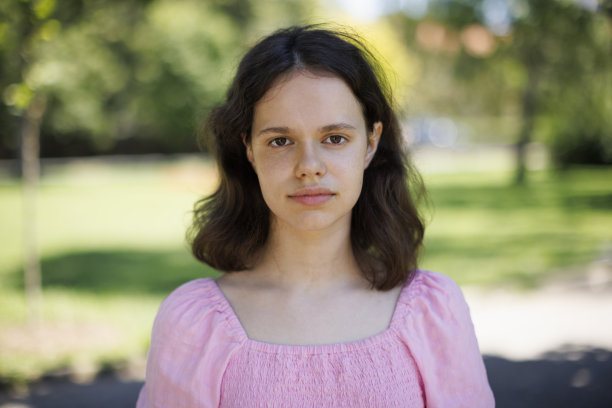 一个微笑着看着相机的女孩的特写肖像图片下载