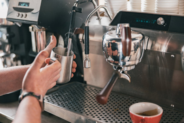 专业咖啡师用咖啡机的蒸汽加热牛奶图片下载