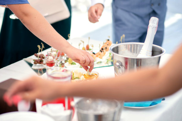 露天自助餐，人们边吃边放松，女孩的手捧着奶酪，泡在蜂蜜里图片下载