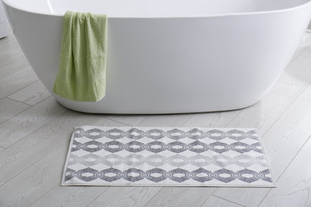 浴室浴缸附近的地板上有时髦的垫子。室内设计图片下载