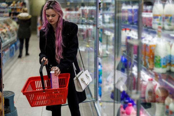 一对年轻的现代夫妇正在市场商店购买食品杂货。图片下载