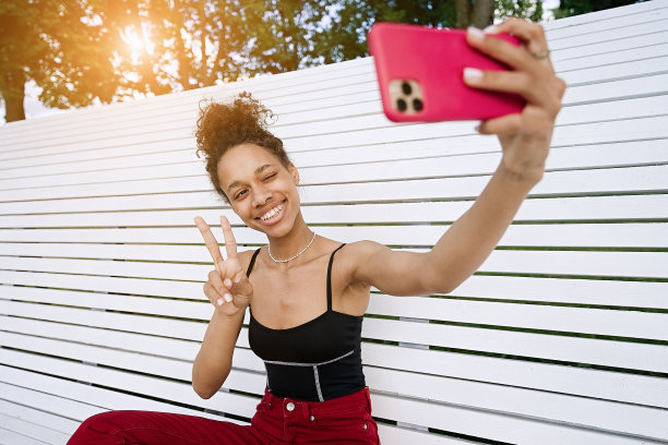 女孩坐在长椅上，通过电话视频聊天图片下载