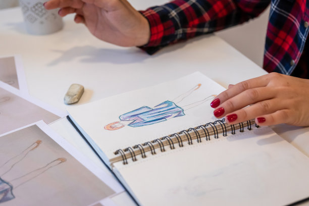 特写镜头的女性手绘时装设计服装到她的素描本图片下载