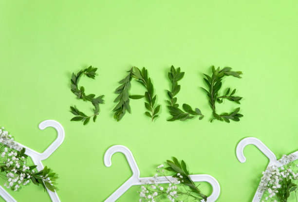 夏季特价广告海报，绿色背景有衣架和鲜花。附有购物邀请的传单。模板提供折扣交易。图片下载