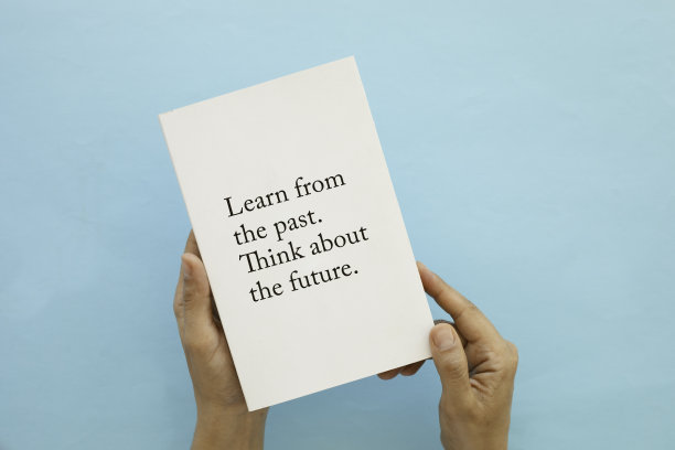 蓝色背景下拿着书的女人图片下载