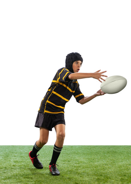 一个活泼的男孩，孩子，男性橄榄球运动员与球隔离在白色背景与草地地板训练。运动、团队、学习、技能概念图片下载