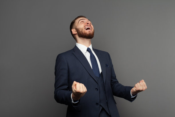 幸福成功的商人穿着西装玩的肖像。企业成功、赢、善的理念。图片下载
