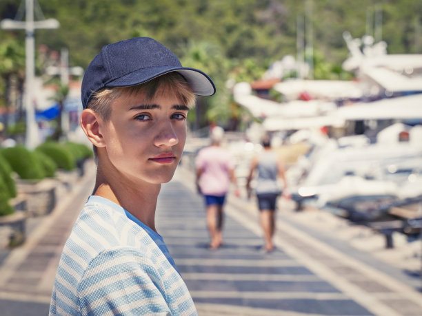 英俊的少年戴着黑色空白棒球帽与空间为您的标志或设计图片下载