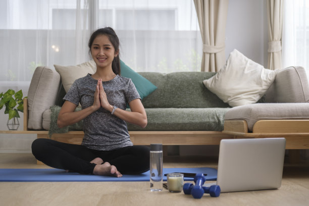 美丽的年轻女子在客厅做瑜伽或普拉提运动。健康的生活方式，瑜伽，普拉提，运动理念。图片下载