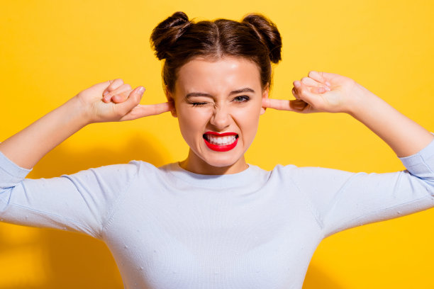 愤怒的女士的照片受嘈杂的音乐隐藏耳朵手指隔离鲜明的色彩背景图片下载