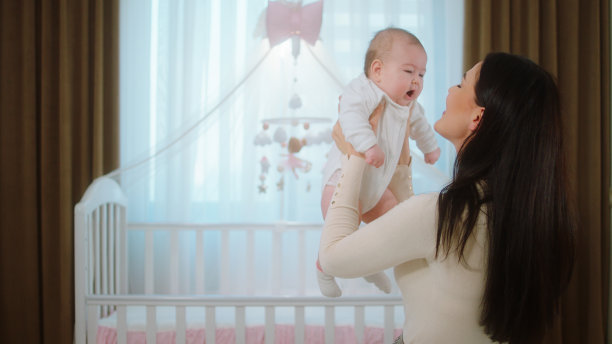 母性概念的年轻妈妈和她的宝贝女儿在卧室里相互拥抱，非常可爱，他们一起超速的时间图片下载